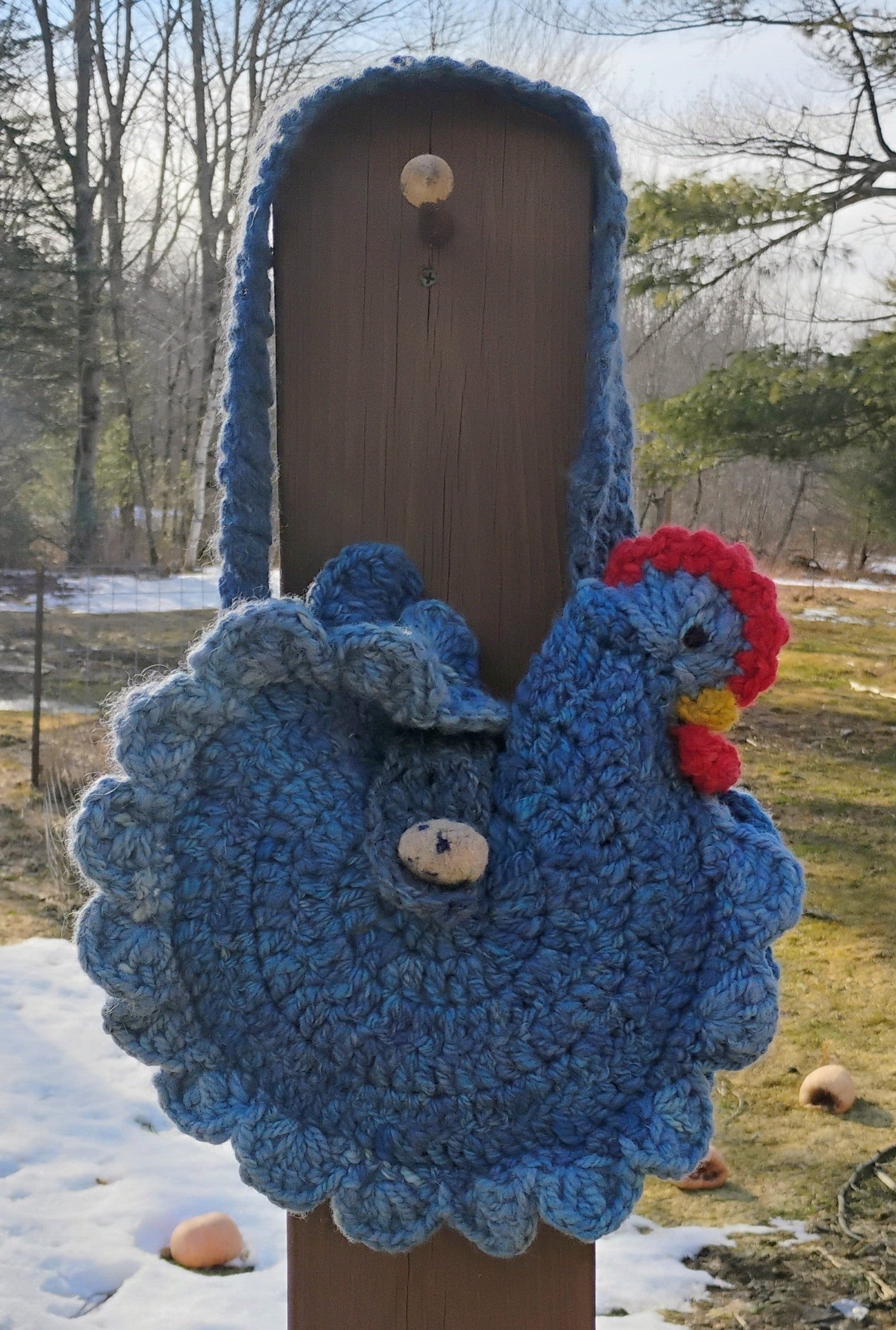 The Laying Hen handspun wool crochet chicken bag in denim blue, full front view with egg button closure