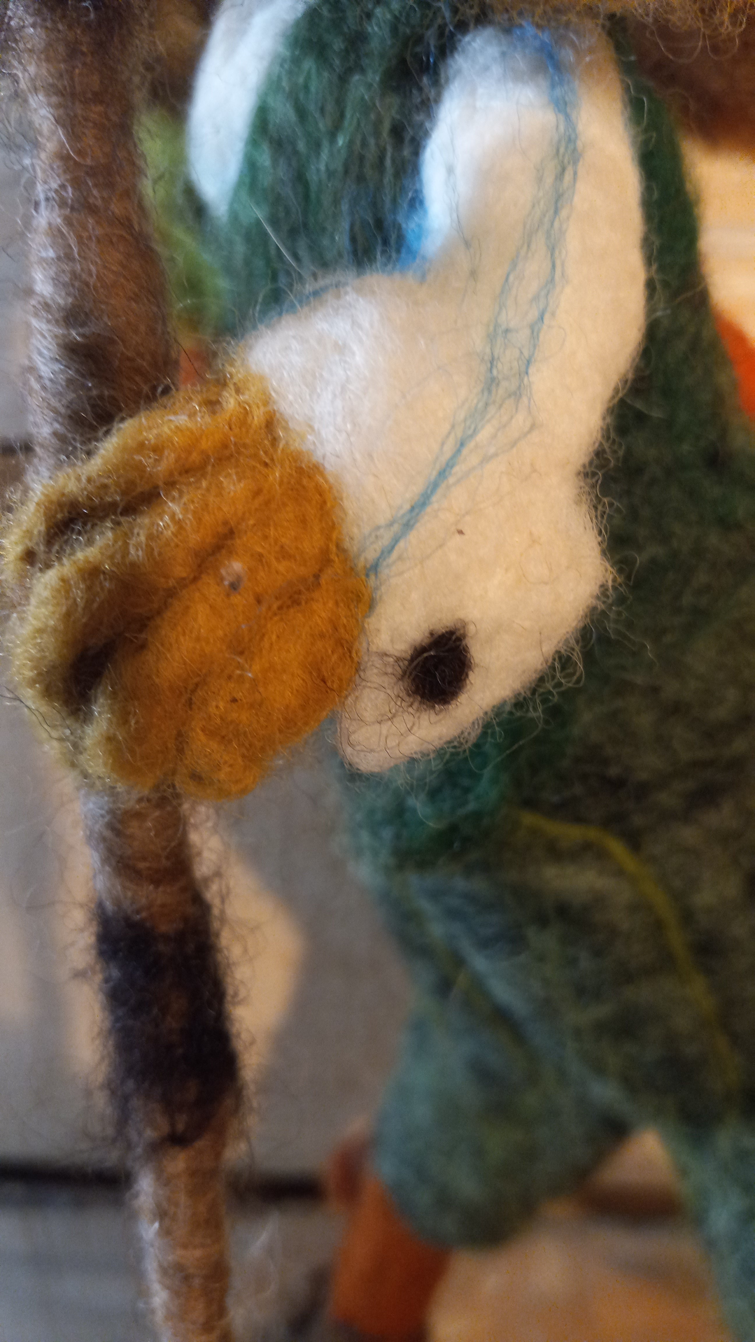 Close-up of felted carrot bundle held by The Carrot Hunter rabbit sculpture