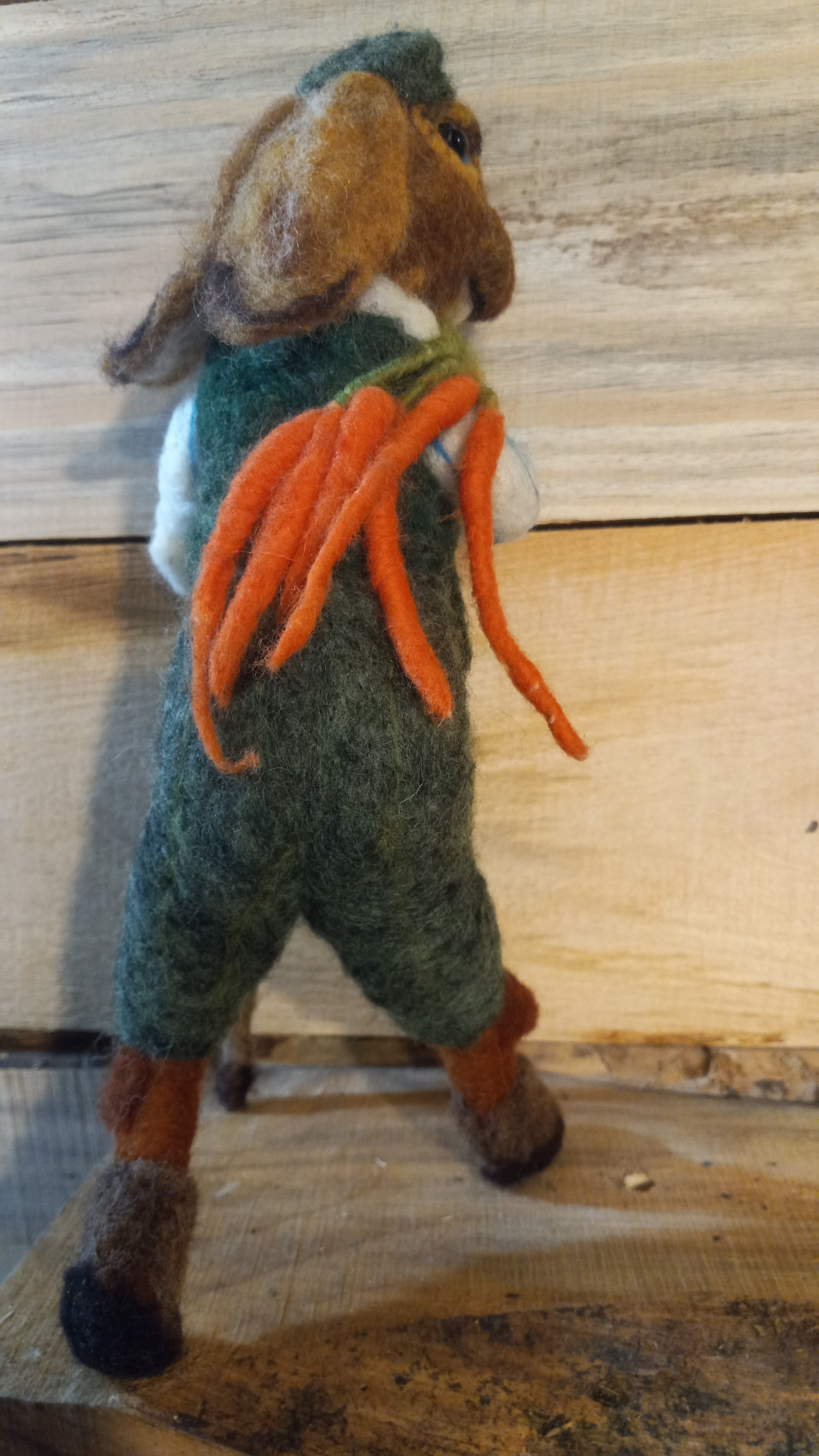 The Carrot Hunter needle felted rabbit sculpture full body side view with carrots and walking stick
